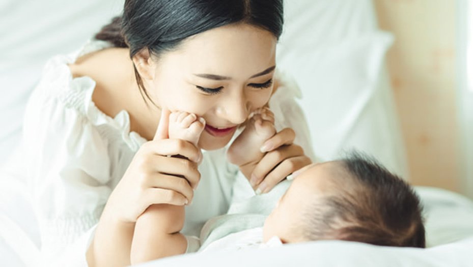 mother playing with newborn child